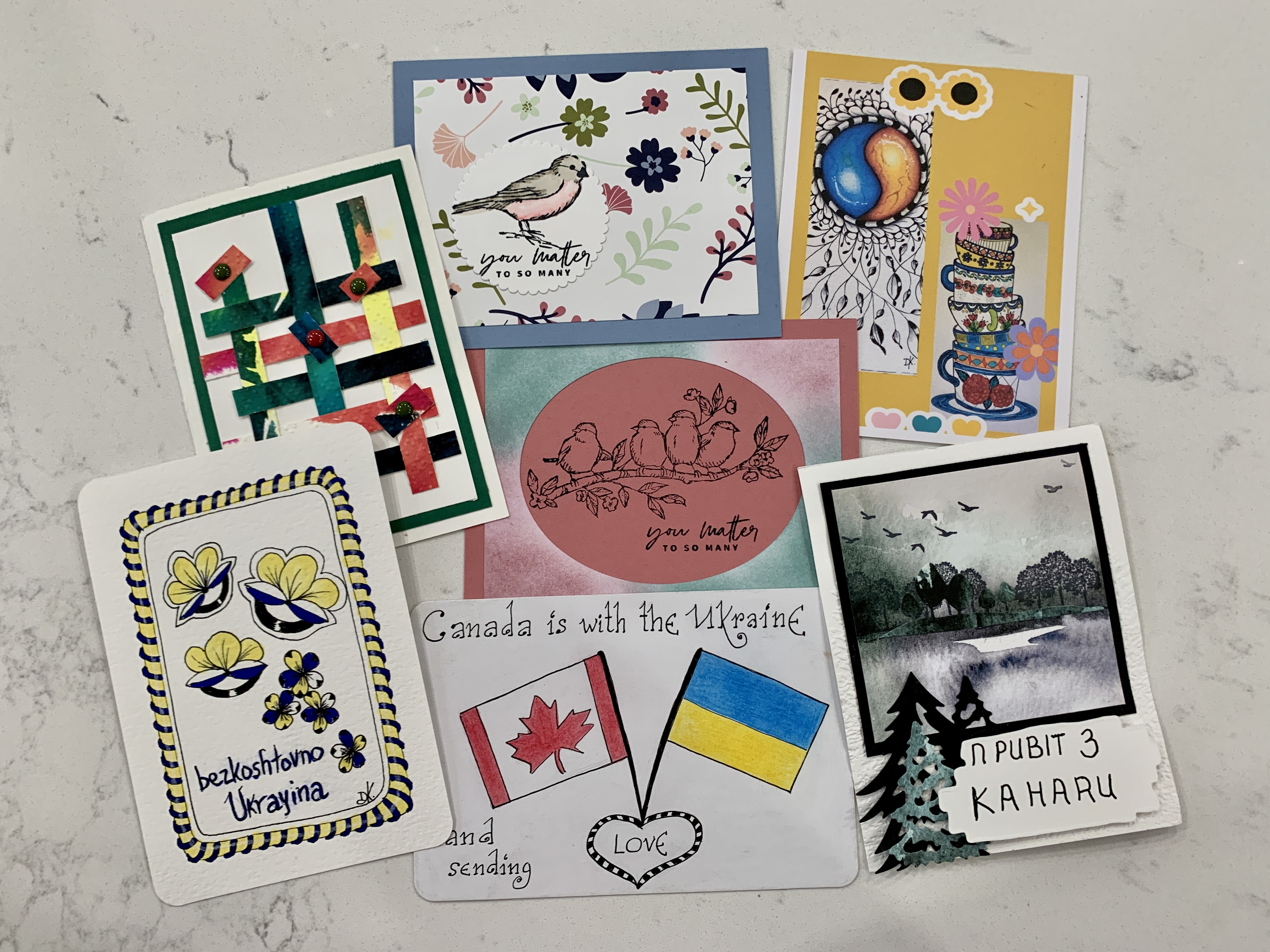 Nine handmade postcards, one showing Canadian and Ukrainian flags with the words Canada is with the Ukraine