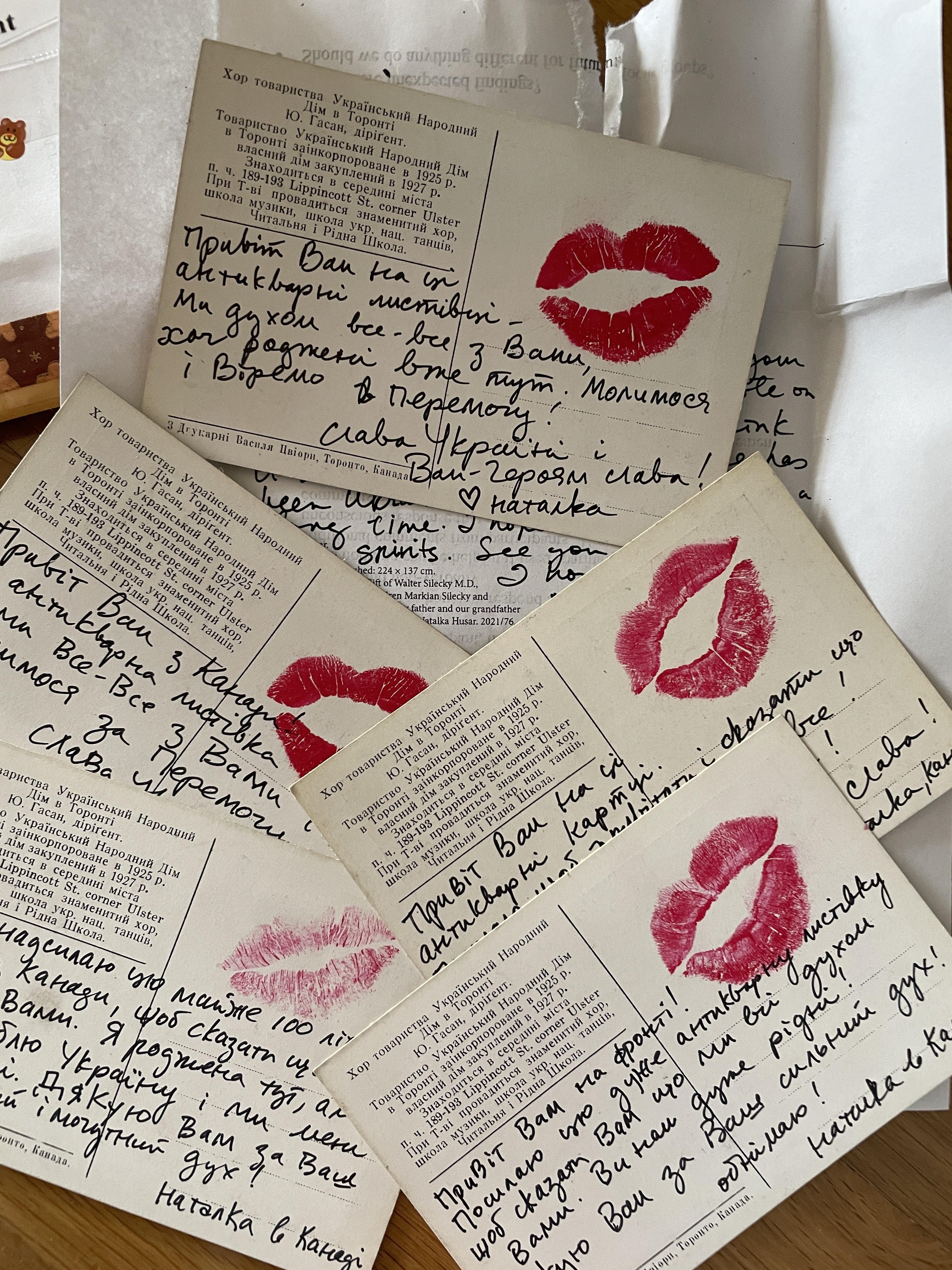Postcards handwritten in Ukrainian, each marked with a red lipstick kiss, signed Наталка and ending Слава Україні